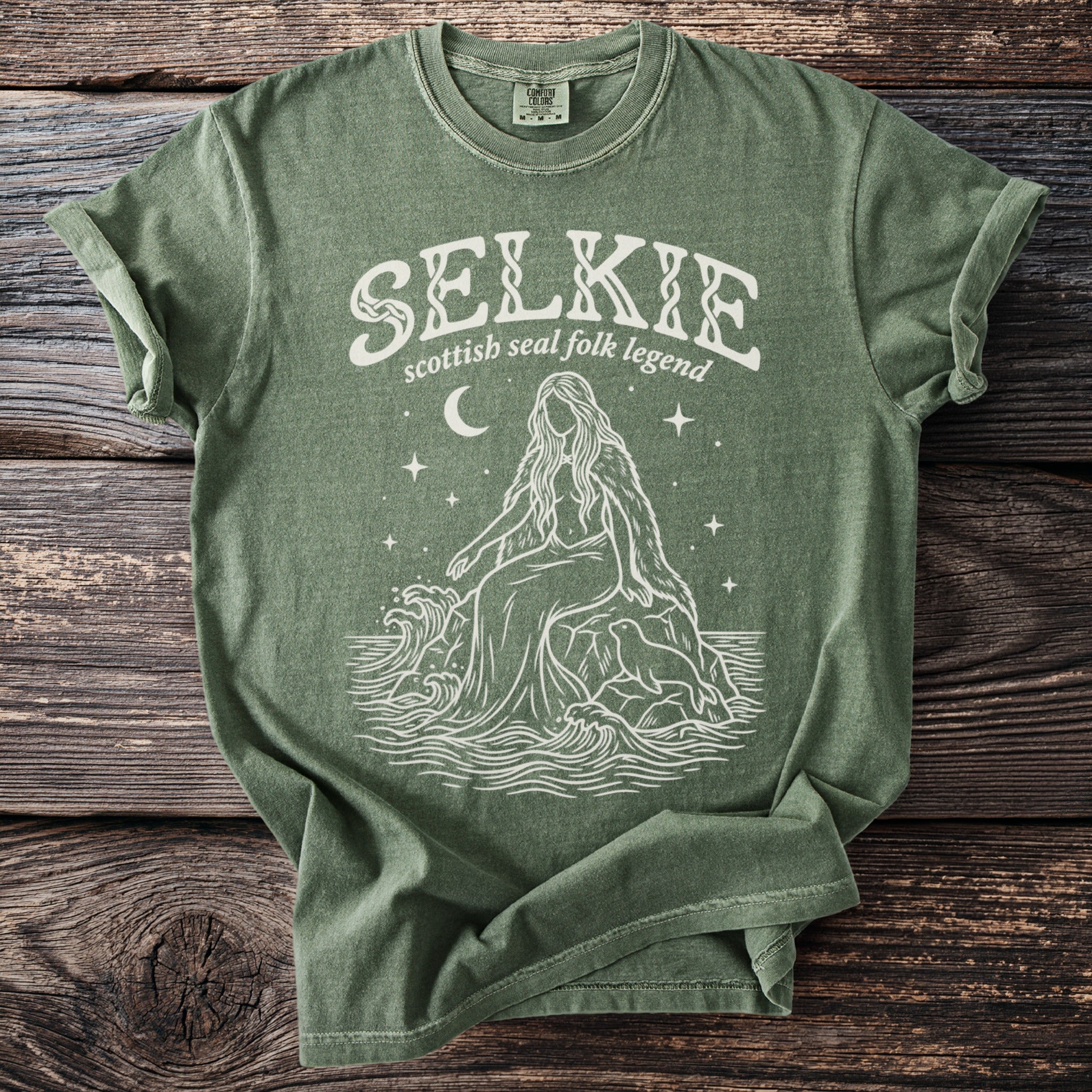 Green t-shirt with white "Selkie Scottish Seal Folk Legend" graphic.