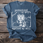 Blue t-shirt with a white distressed graphic of an owl and text reading "perceived against my will."