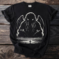 Black t-shirt with white tentacled creature illustration and a small figure.