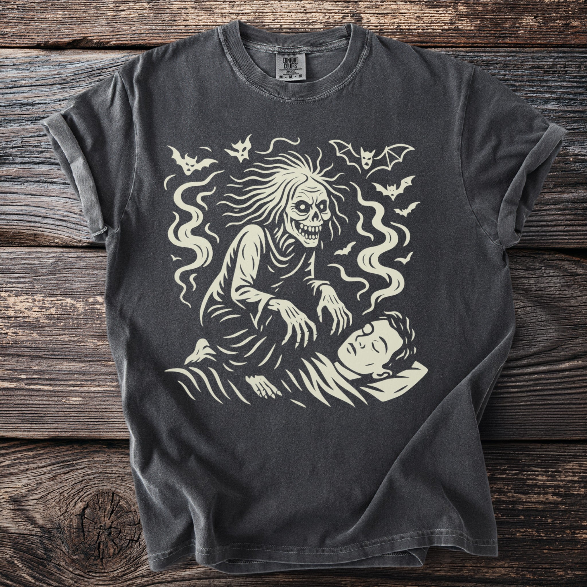 Dark grey t-shirt with a cream graphic of a ghostly figure looming over a sleeping person with bats.
