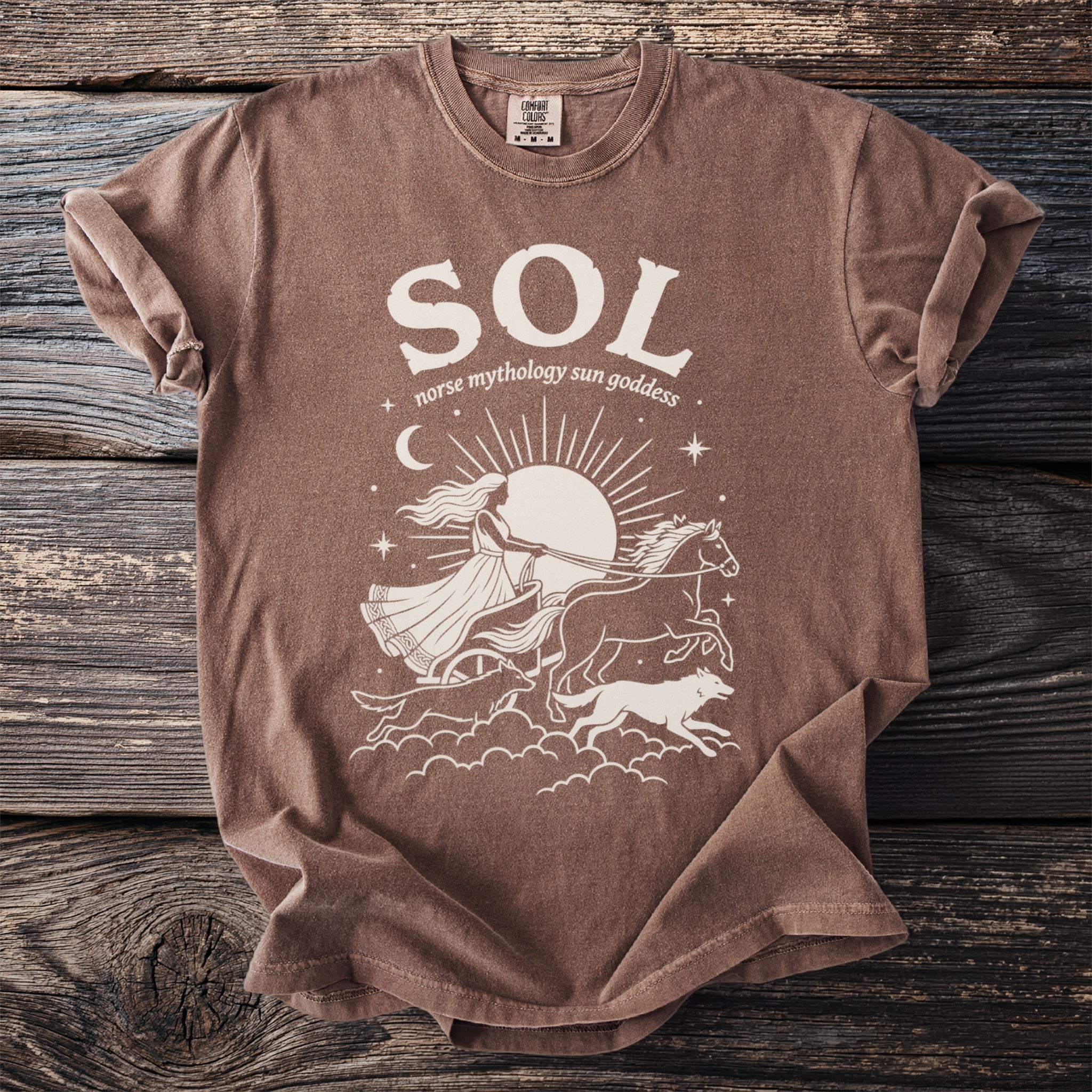 Brown t-shirt with cream graphic of Sol, Norse sun goddess, in chariot pulled by horses and wolves.