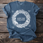 Blue t-shirt with central graphic "LOVE THE UNLOVED" and surrounding illustrated creatures.