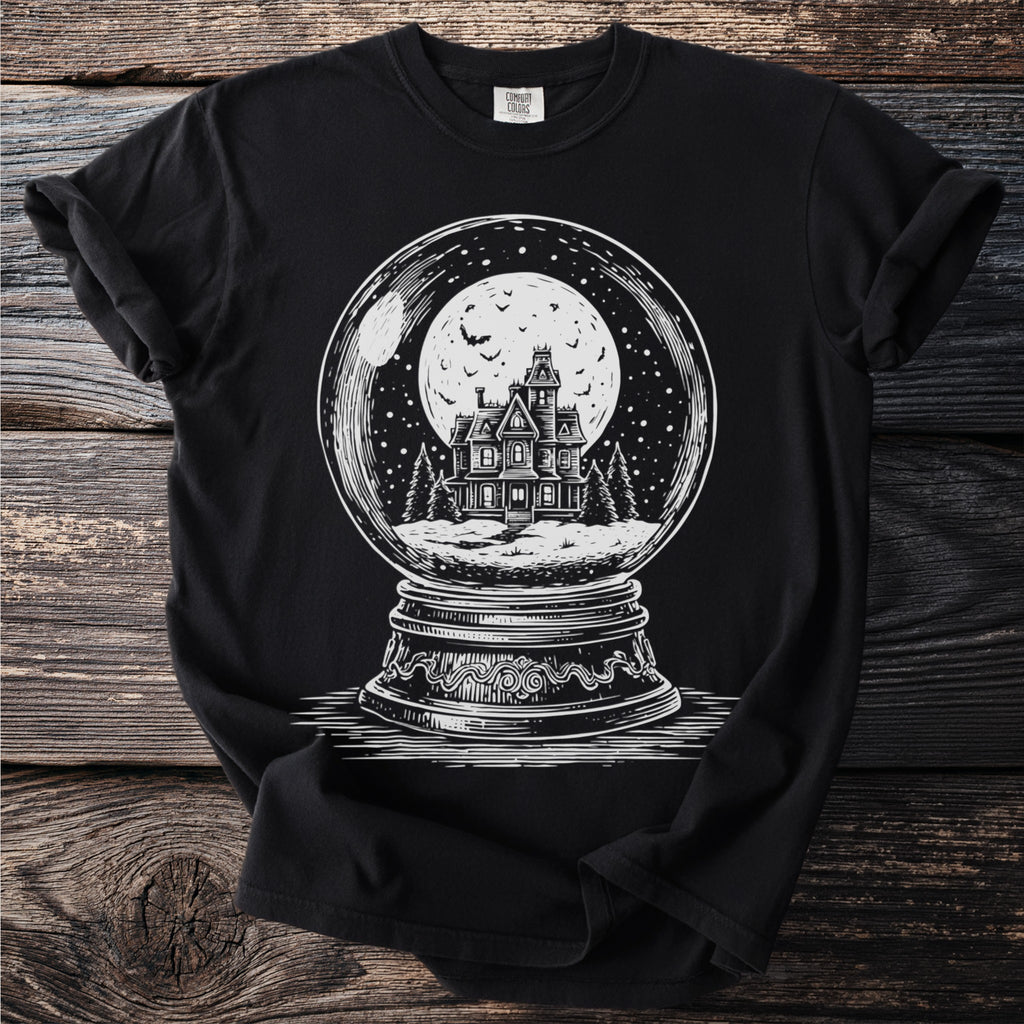 Black t-shirt with a white graphic of a haunted house in a snow globe.