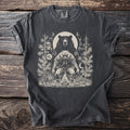 Dark gray t-shirt with a monochrome print of a bear and a man by a campfire.