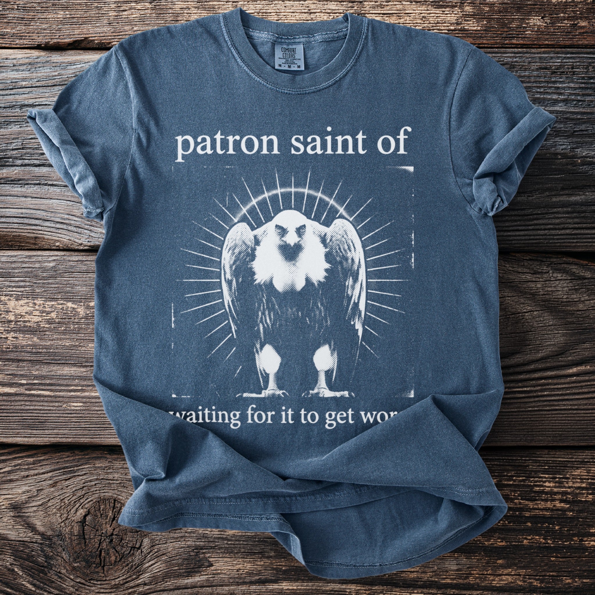 Blue t-shirt with "patron saint of" and a vulture graphic.