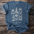 Blue t-shirt with "The Wildflower Meadow" botanical illustration and text.