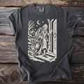 Pepper gray t-shirt with a cream folk-cut print: Marley's ghost stands at a door in the snow, wrapped in chains, padlocks and cash boxes.
