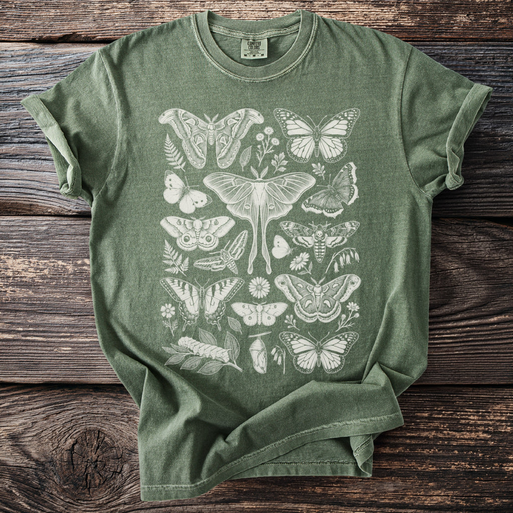 Green t-shirt with cream colored butterfly and moth illustrations.