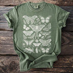 Green t-shirt with cream colored butterfly and moth illustrations.