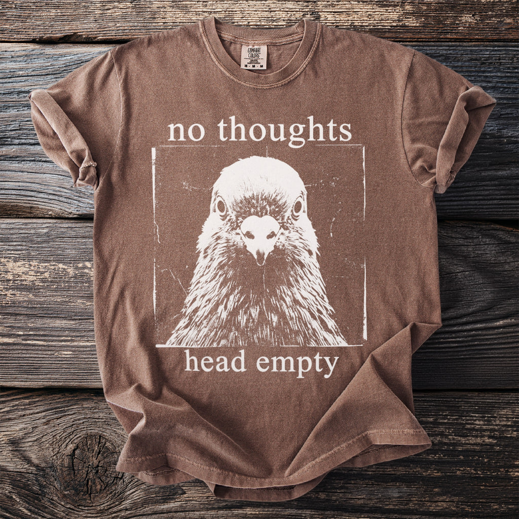 Brown t-shirt with white screen-print of a pigeon and text "no thoughts head empty".