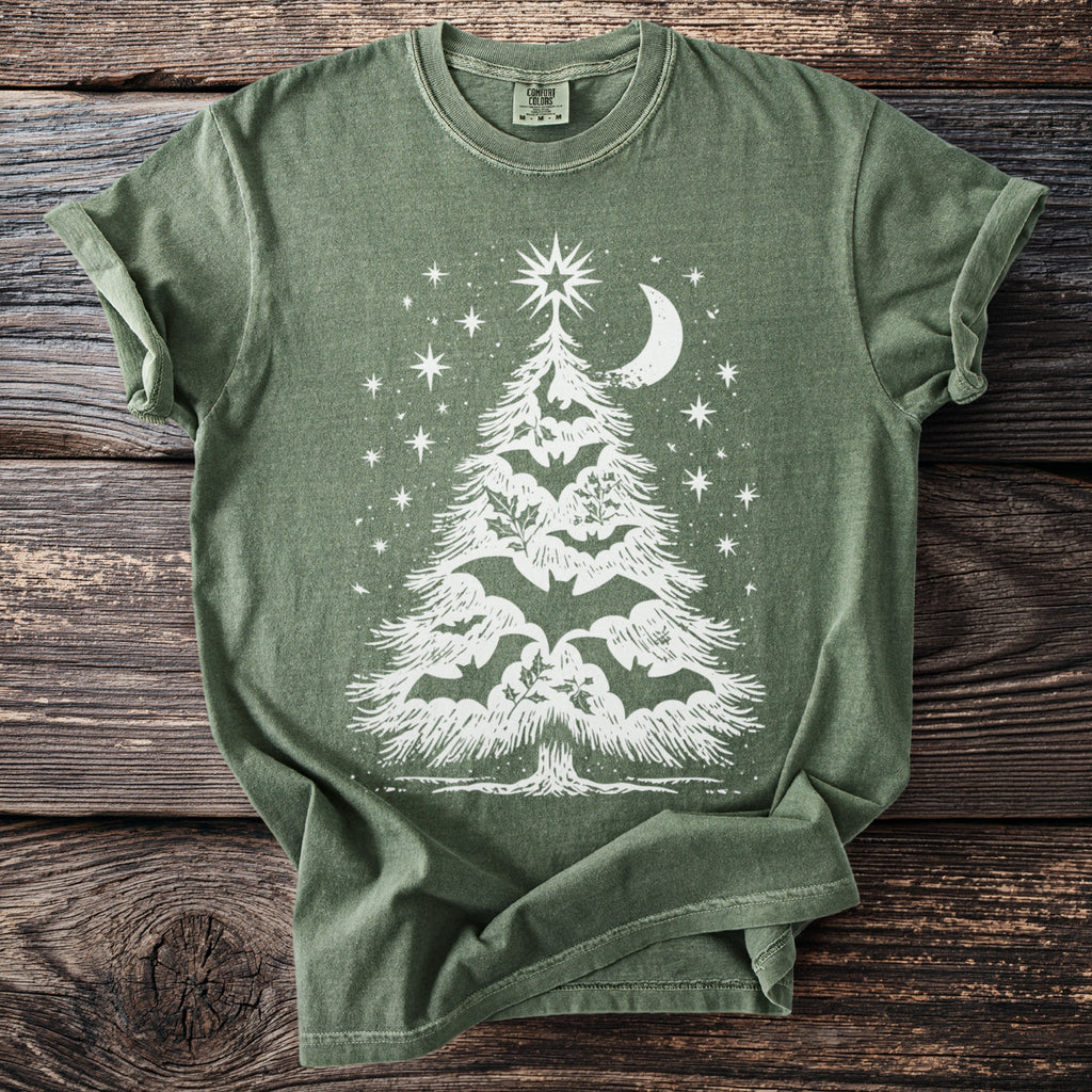 Green t-shirt with white Christmas tree design featuring bats, holly, stars, and a crescent moon.