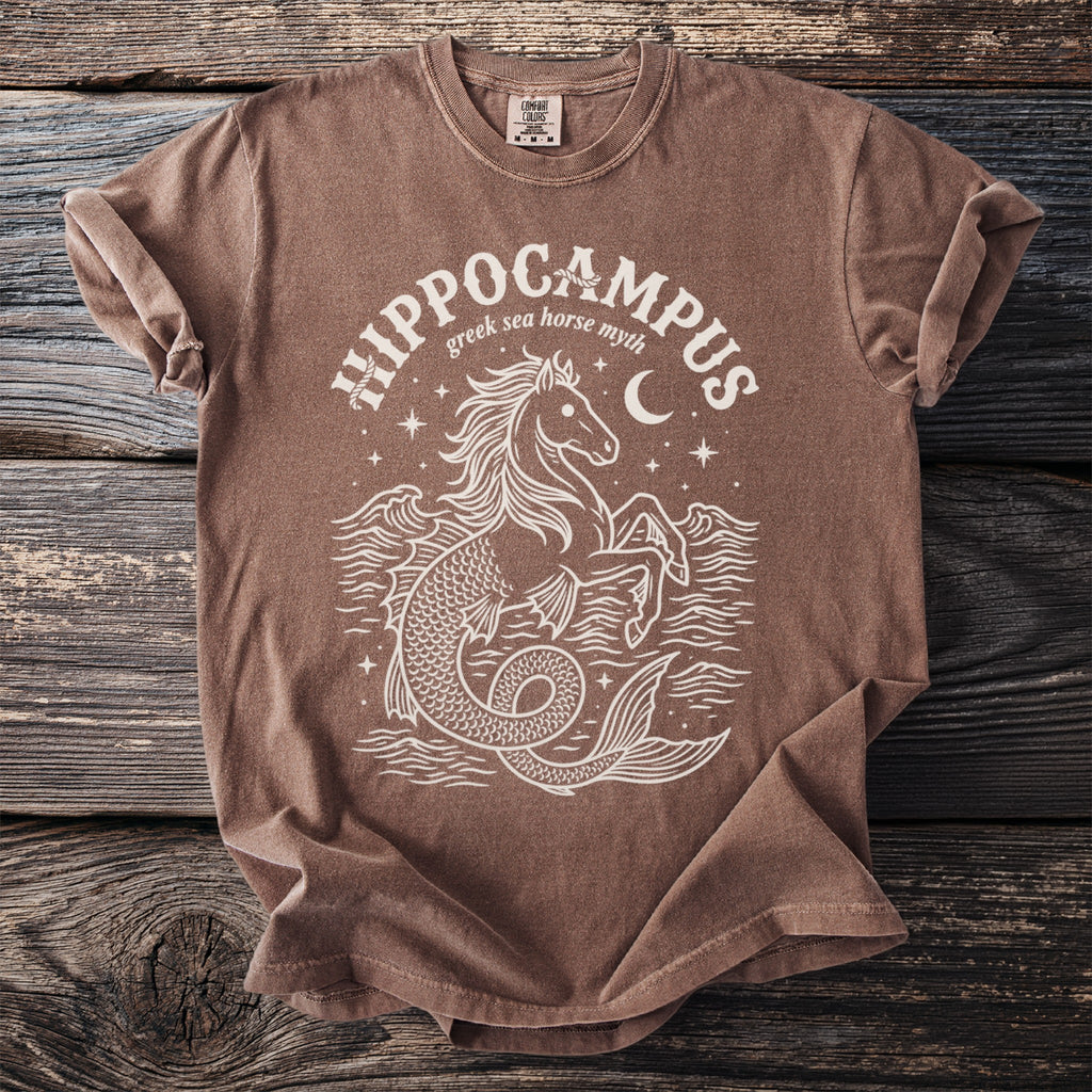 Brown t-shirt with white print of a hippocampus, wavy water, and a moon.