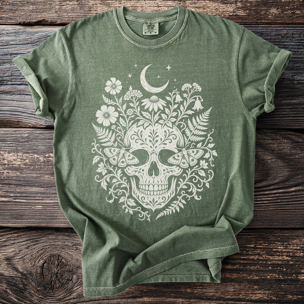 Green t-shirt with white skull, moon, flowers, ferns, and moths design.
