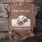 Brown t-shirt with a close-up snail graphic and text reading "slugs are just homeless snails."
