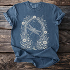 Blue comfort colors t-shirt with a white dragonfly and floral moonlit forest design.