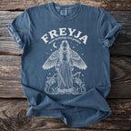 Blue t-shirt with white graphic of Freyja, two cats, and chariot.