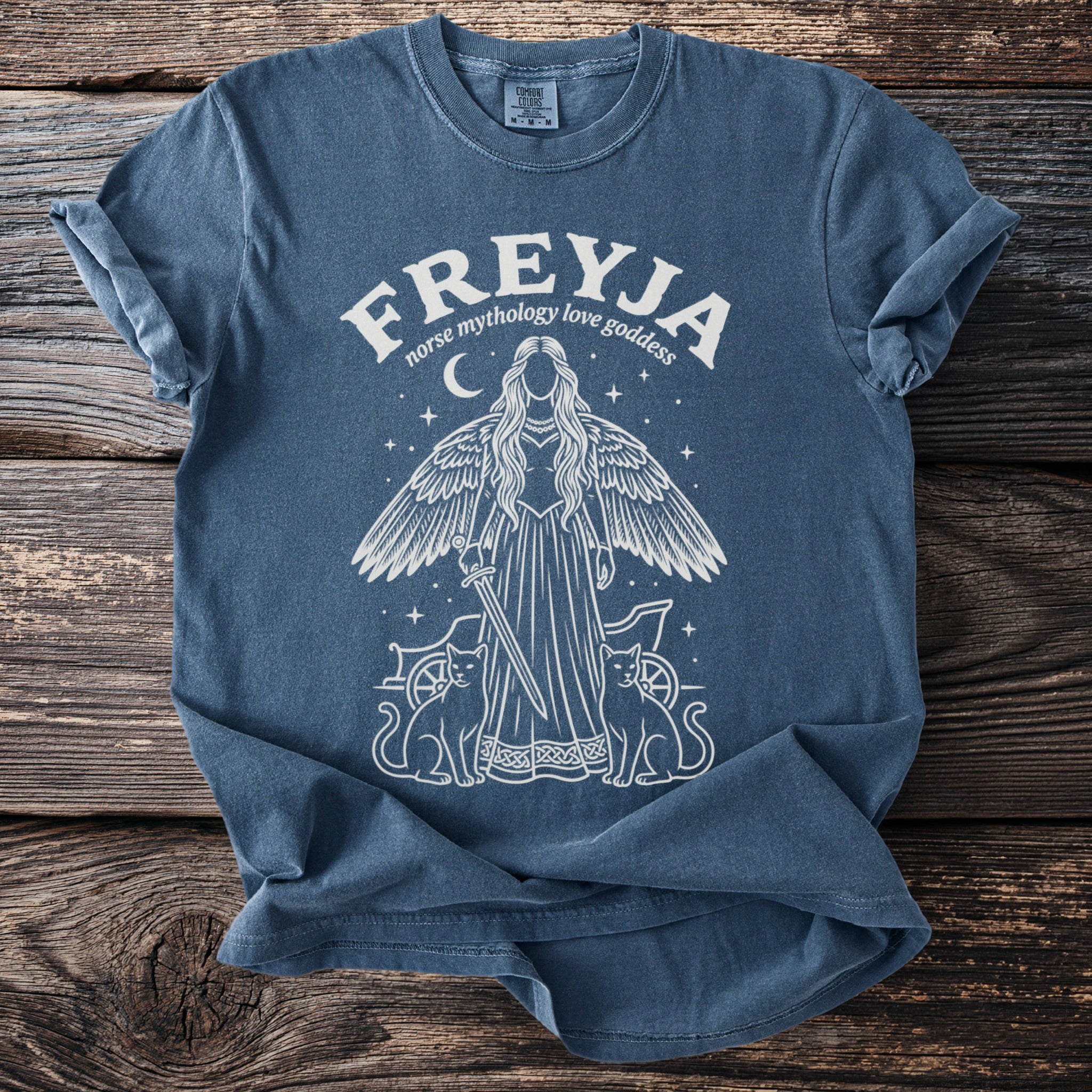 Blue t-shirt with white graphic of Freyja, two cats, and chariot.