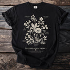 Black t-shirt with "The Meadow Cabinet" and wildflower illustrations, identified by name.