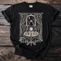 Mystic scene with robed figure, crystal ball, tarot cards, and cat, on a black shirt.