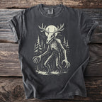 Dark grey t-shirt with a skeletal creature with antlers and long claws in a forest.