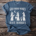 Blue t-shirt with white text and graphics of three witches.