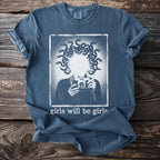 Blue t-shirt graphic of Medusa holding a camera with text "girls will be girls".