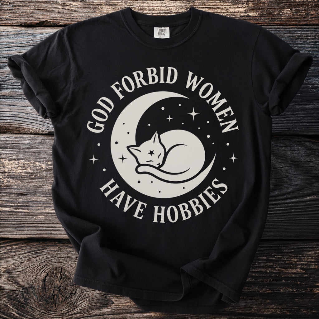 Black t-shirt with white text and graphic of a cat sleeping on a crescent moon.