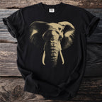 Black t-shirt with a gold, detailed elephant face graphic and Comfort Colors tag.