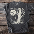 Dark t-shirt with a cream graphic of a tree, full moon, bats, and a lantern.