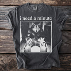 Dark t-shirt with "i need a minute" text and a werewolf holding a kitten.