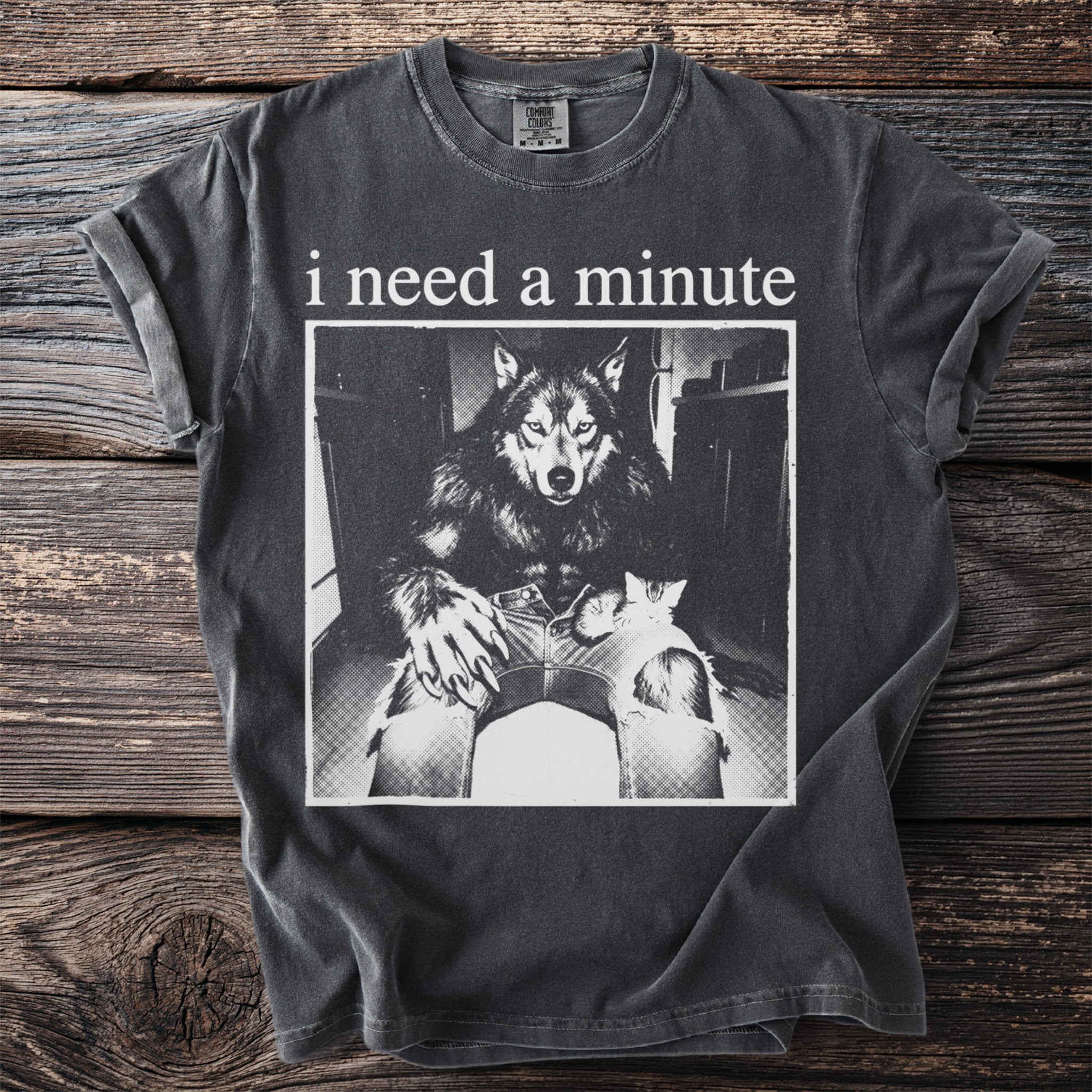 Dark t-shirt with "i need a minute" text and a werewolf holding a kitten.