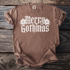 Brown t-shirt with white "Merry Gothmas" text, skulls, and poinsettias.