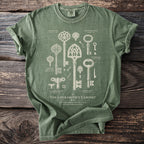 Green t-shirt with vintage key illustrations and text "The Locksmith's Cabinet".