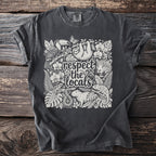 Dark grey t-shirt with a white artistic design of rainforest animals and plants.