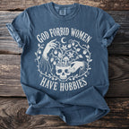 Blue t-shirt with white text and skull graphic saying "God Forbid Women Have Hobbies".