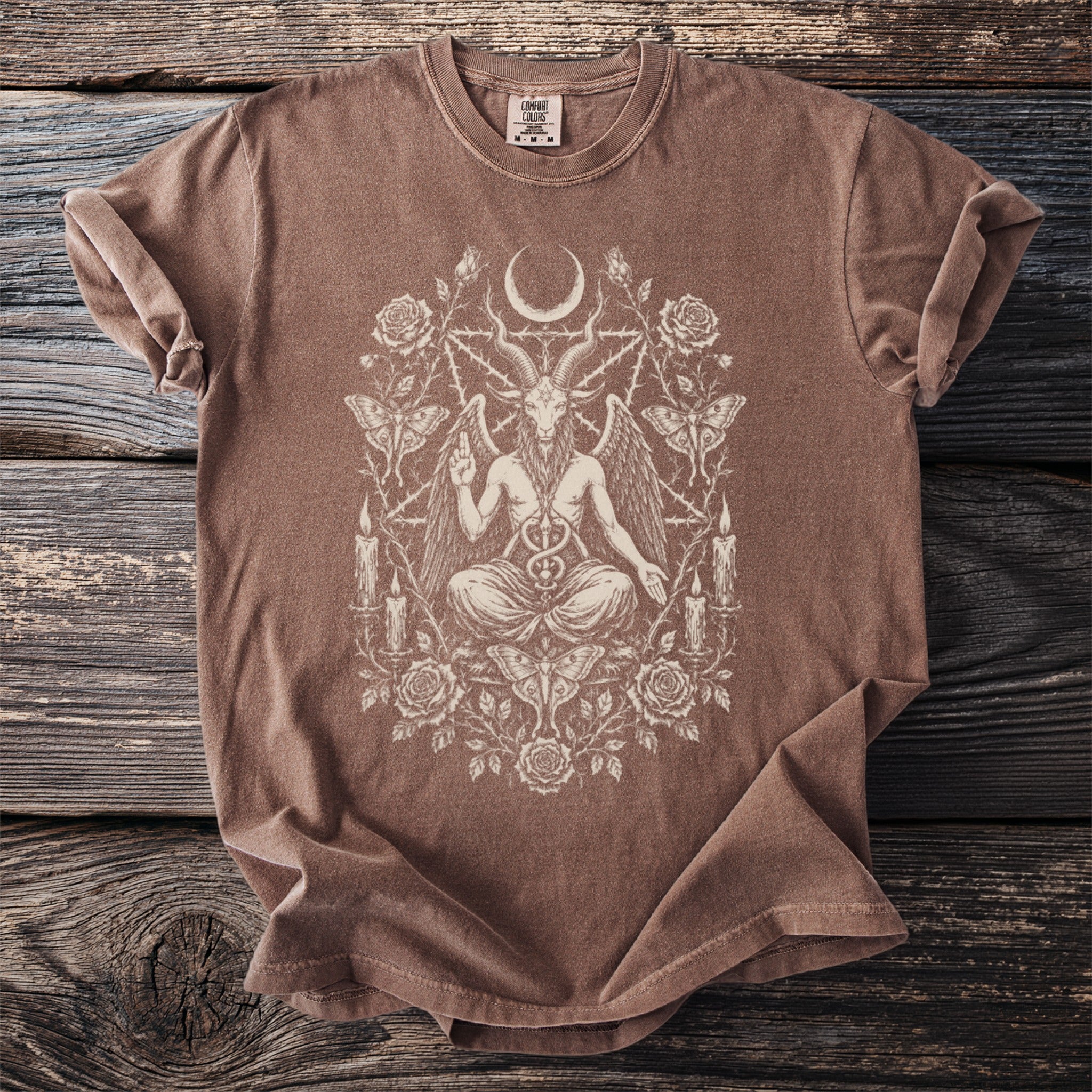 Brown t-shirt with a cream-colored occult design featuring Baphomet, moon, roses, and moths.