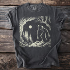 Dark t-shirt with a graphic of a creature in a forest under moonlight.