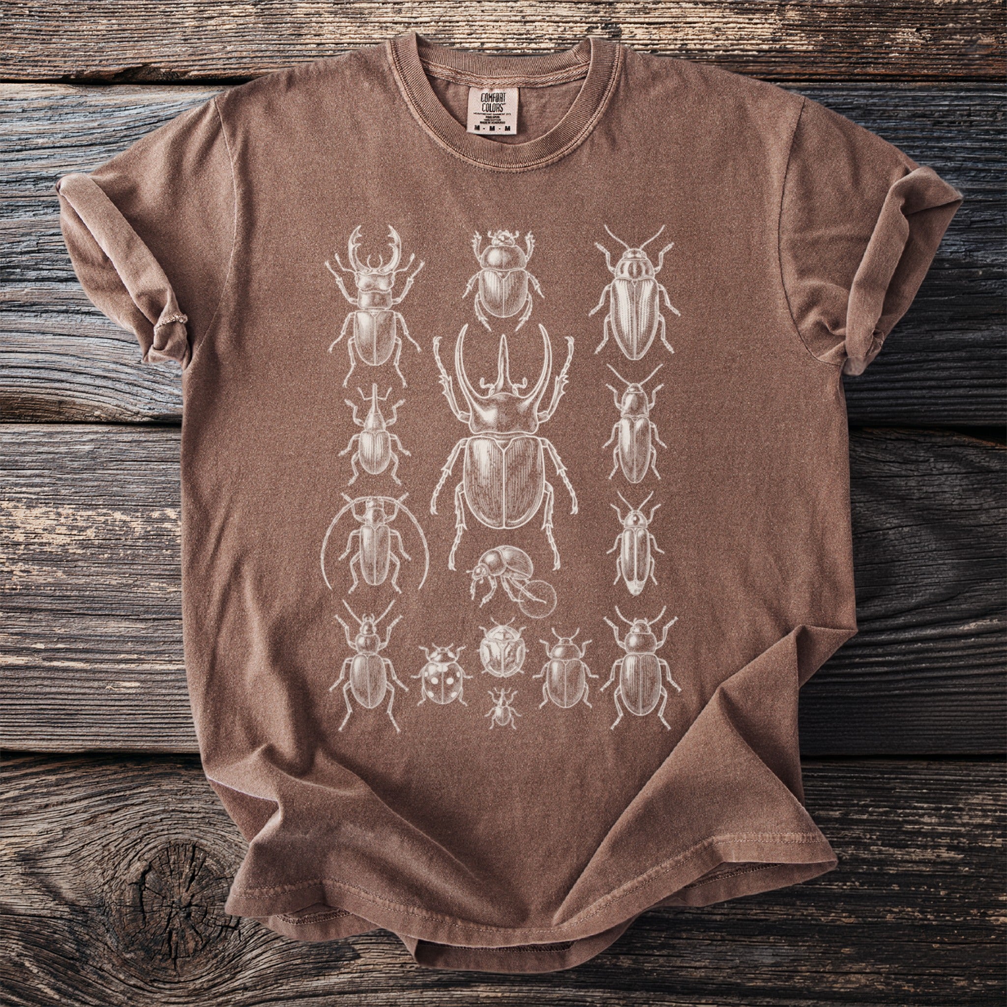 Brown t-shirt with white vintage beetle illustrations.