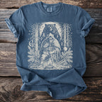 Blue t-shirt featuring a Viking warrior, bear, and runes in a forest setting.