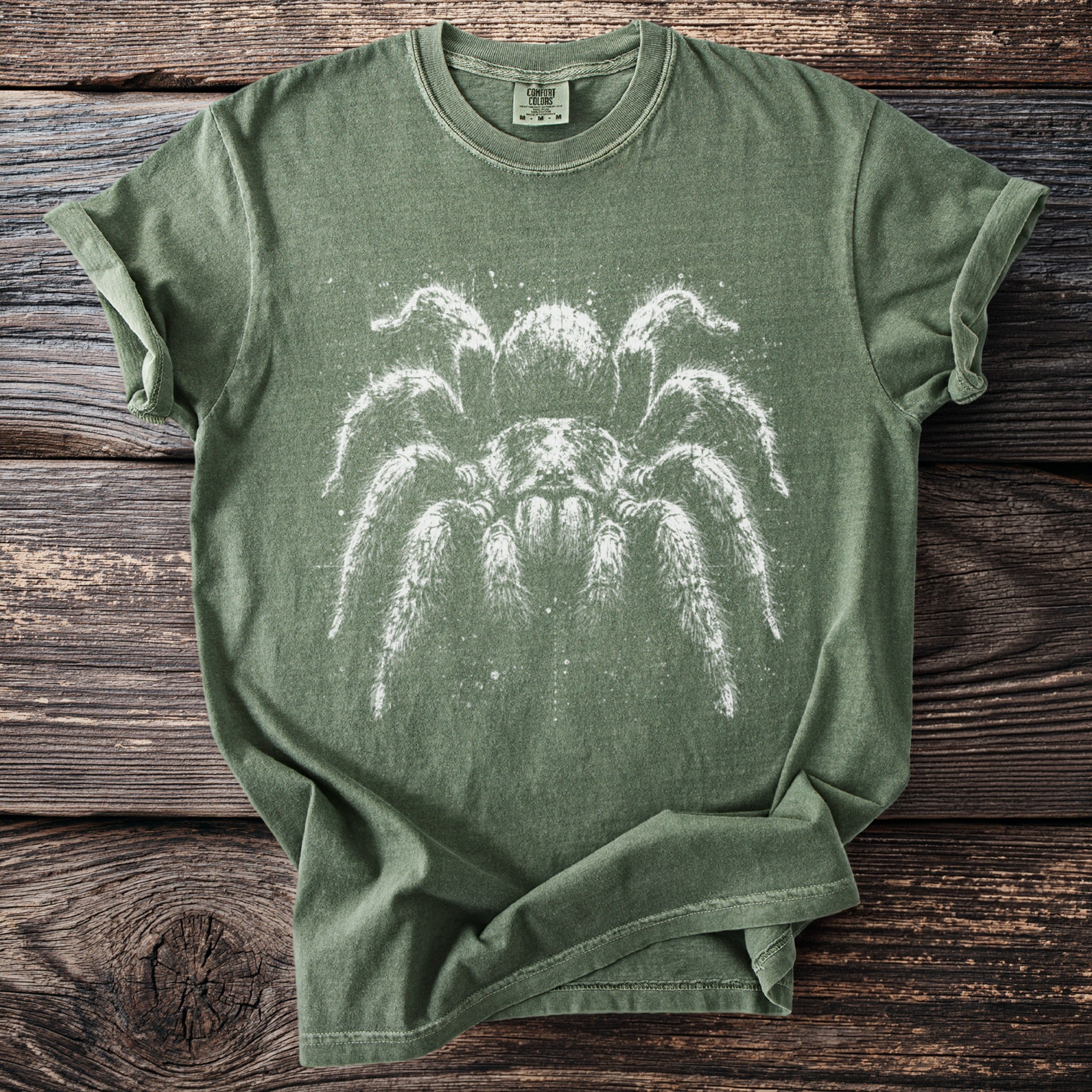 Green t-shirt with a white close-up graphic of a tarantula.