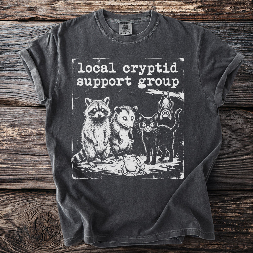 T-shirt with "Local cryptid support group" and drawings of raccoon, opossum, black cat, and frog.