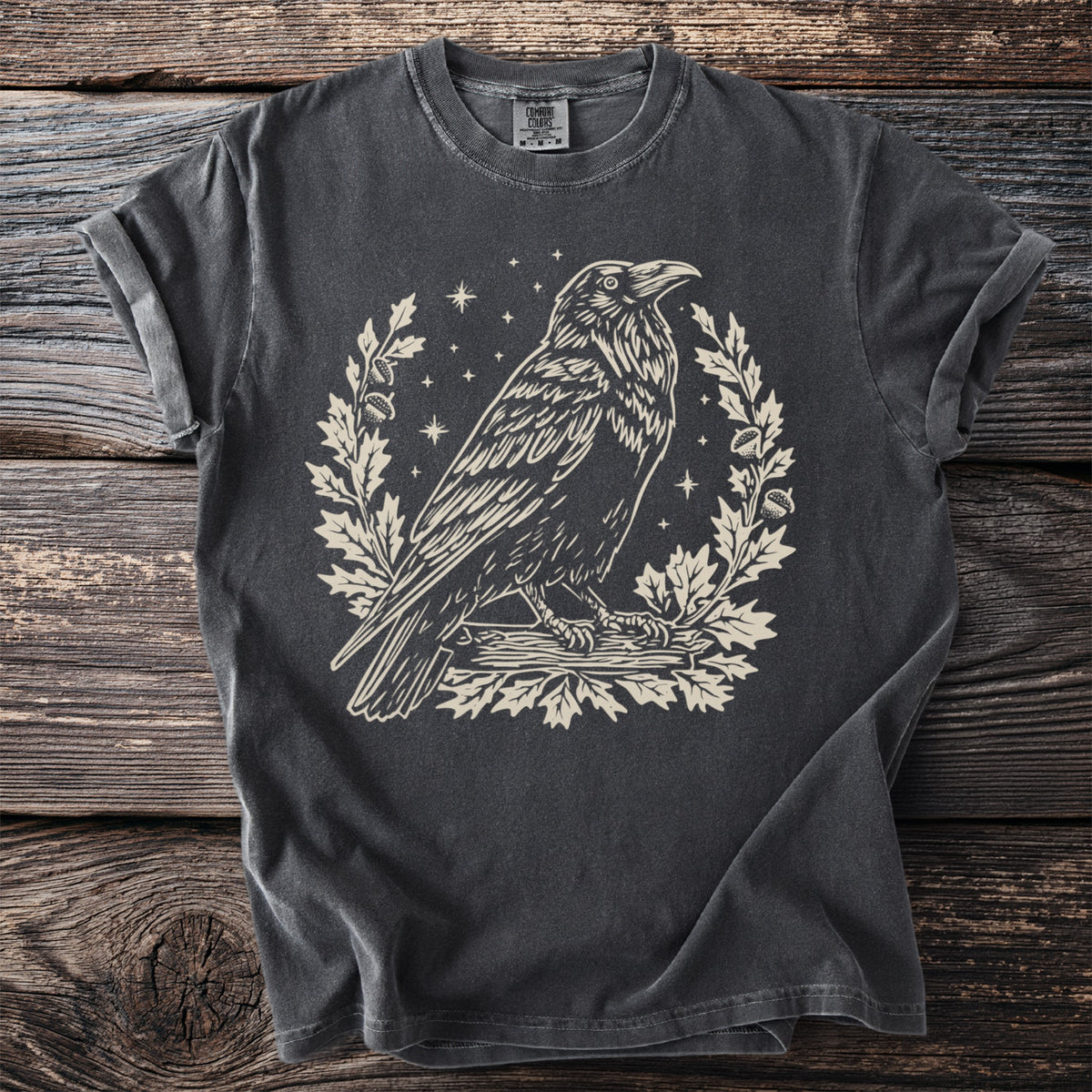 Dark gray t-shirt with raven, oak leaves, and stars graphic print.