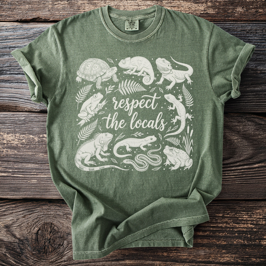 Green t-shirt with white line art of various reptiles and amphibians surrounding text.