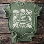 Green t-shirt with white line art of various reptiles and amphibians surrounding text.