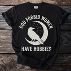 Black t-shirt with a crow on a crescent moon and "God Forbid Women Have Hobbies" text.