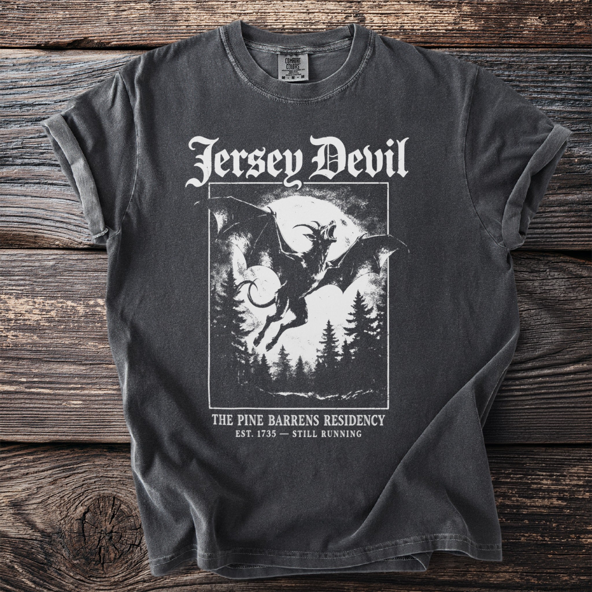 Dark grey t-shirt featuring "Jersey Devil" graphic and "The Pine Barrens Residency" text.