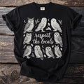 Black t-shirt featuring a graphic of various owls and oak leaves with text that reads "respect the locals."