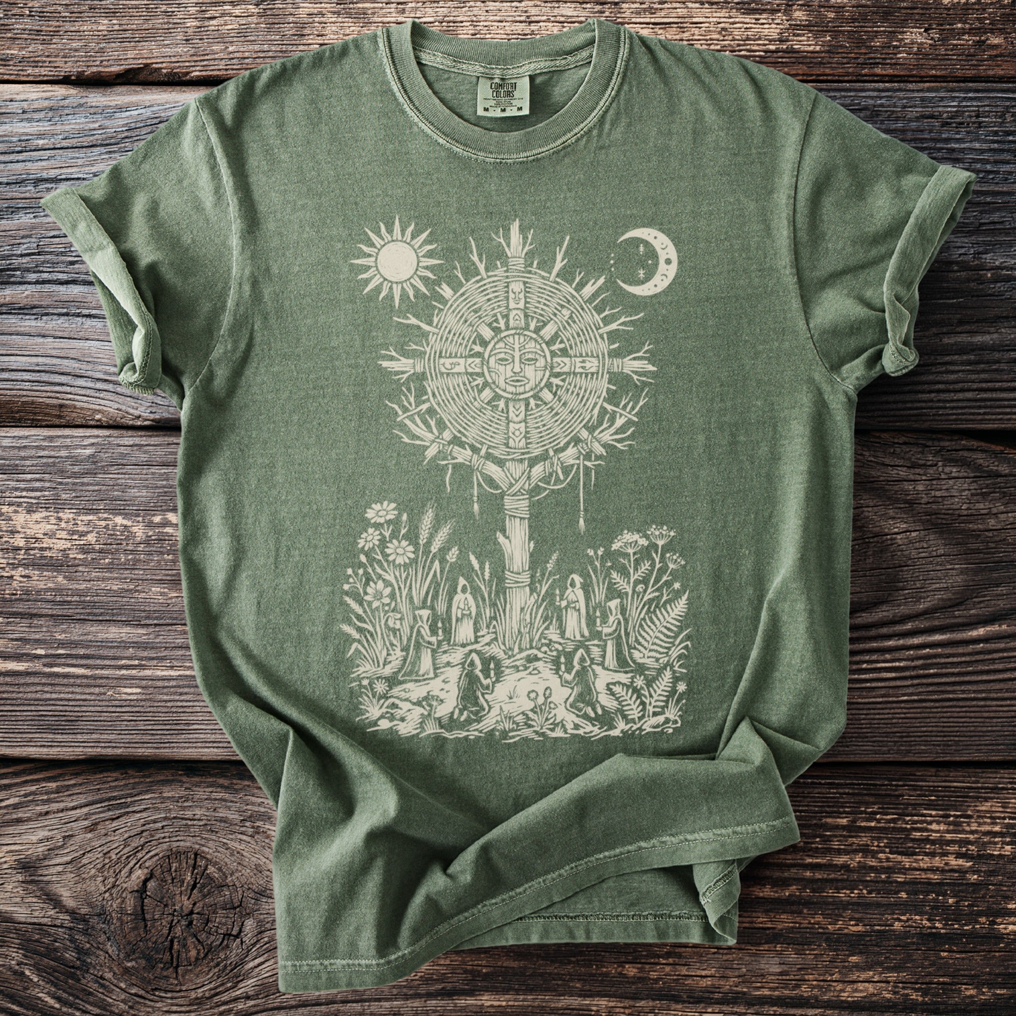 Green t-shirt with sun, moon, and druidic scene graphic of figures in a circle.