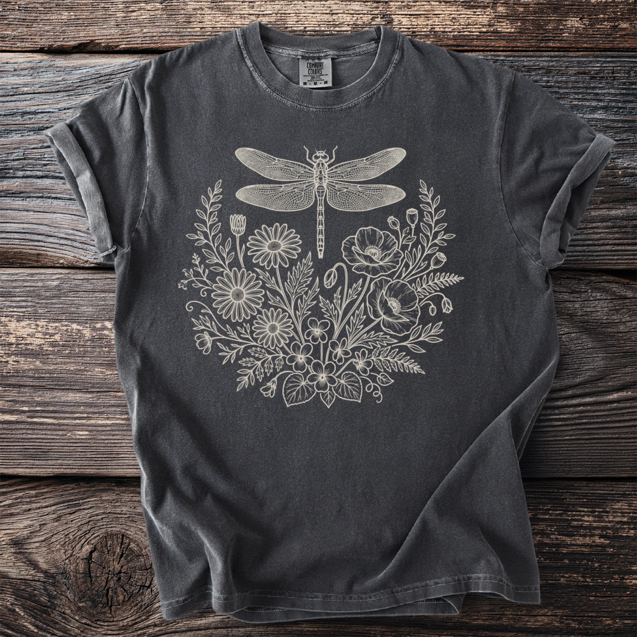 Dark grey t-shirt with a cream outline of a dragonfly over floral elements.