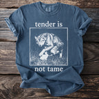 Blue t-shirt with wolf and rabbit graphic and text "tender is not tame."